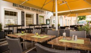 um restaurante ao ar livre com mesas, cadeiras e guarda-sóis em Hotel Brummeier em Eferding