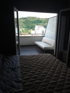 a bedroom with a bed and a couch and a window at Uniclub House in Cosenza