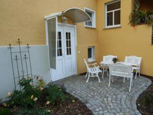 eine Terrasse mit einem Tisch und Stühlen neben einem Gebäude in der Unterkunft Ferienwohnung Simone in Radebeul