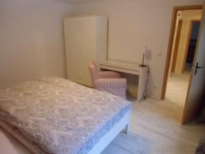 a bedroom with a bed and a desk and a chair at Ferienwohnung Simone in Radebeul