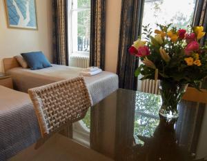 Pokój z wazą kwiatów na stole w obiekcie Euro Hotel w Londynie