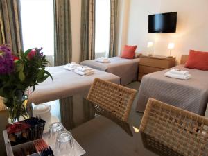 a hotel room with two beds and a table with chairs at Euro Hotel in London