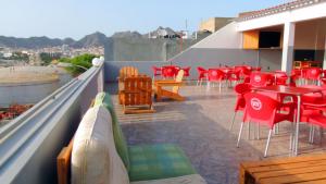 uma varanda com mesas vermelhas e cadeiras num telhado em Mix 2 em Mindelo