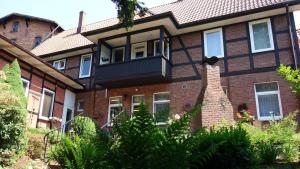 ein Backsteinhaus mit Balkon in der Unterkunft Wassermühle Eldingen in Eldingen