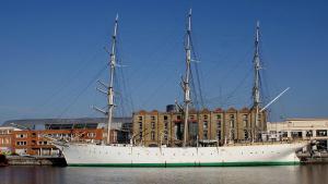 un gran barco sentado en el agua junto a un edificio en Les pièces du puzzle, en Dunkerque