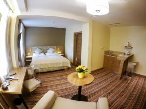 a large hotel room with a bed and a table at Hotel Drei Raben in Graz