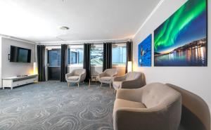 um quarto de hotel com cadeiras e uma televisão e uma sala de espera em Thon Partner Hotel Narvik em Narvik