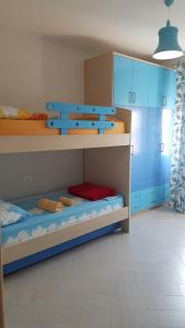 Pokój z 2 łóżkami piętrowymi i niebieskimi szafkami w obiekcie Modern cozy apartment seaview we Wlorze