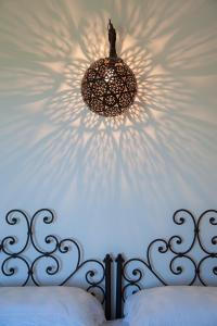 a chandelier hanging over a bed with a white wall at Masseria Montelauro in Otranto