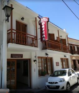 a white car parked in front of a building at Hotel Orfeas in Delfoi