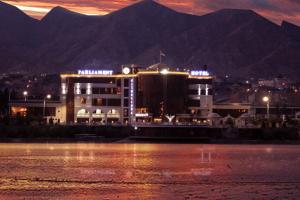 a building next to a body of water at night at Parliament Palace Hotel in Khujand