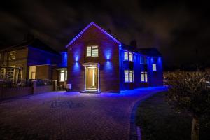 uma casa com luzes azuis na frente em TA House em Edgware
