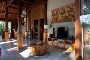 a living room with a tv and a coffee table at Casa Ola Villa Pererenan in Canggu
