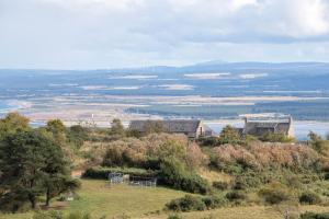 a house on a hill with a view of the water at Dolphin View Hillockhead in Rosemarkie