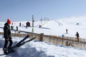 uma pessoa ao lado de uma cerca com esquis na neve em Luna Hotel Serra da Estrela na Covilh�