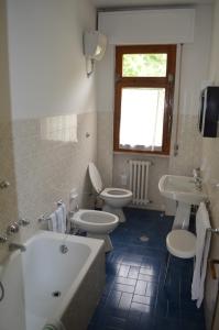 a bathroom with two toilets and a tub and sinks at Albergo Padellino in Vaglia