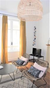 een woonkamer met stoelen, een tafel en een piano bij Le Sainte Barbe in Saint-Malo