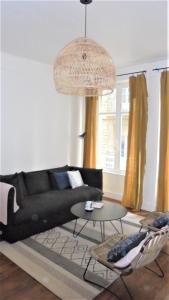 een woonkamer met een zwarte bank en een tafel bij Le Sainte Barbe in Saint-Malo
