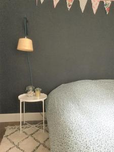 een slaapkamer met een bed en een tafel met een lamp bij Le Sainte Barbe in Saint-Malo