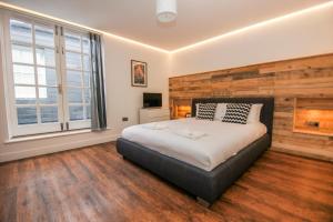 ein Schlafzimmer mit einem großen Bett und einem Kamin in der Unterkunft Steine House - Central- by Brighton Holiday Lets in Brighton & Hove