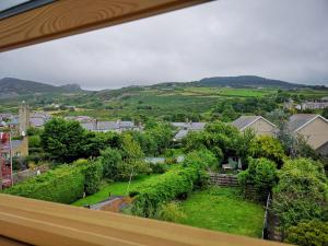 a view of a garden from a window of a house at Ty Isa in Nefyn