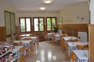 un comedor con mesas, sillas y ventanas en Albergo Padellino en Vaglia