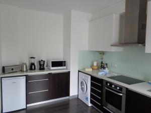 a kitchen with a dishwasher and a washer and sink at Sun with Style in Figueira da Foz