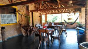 a restaurant with tables and chairs in a room at Repousada Chalés in Conceição da Ibitipoca