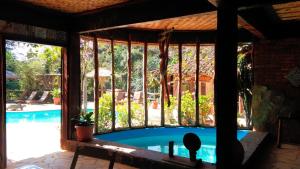 a screened in porch with a swimming pool at Repousada Chalés in Conceição da Ibitipoca