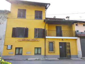 een geel gebouw met zwarte ramen en een balkon bij Spighe Paglia e Girasole in Candia Canavese