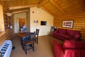 a living room with a red couch and a table at Cody Cowboy Village in Cody
