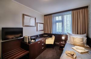 a hotel room with a bed and a desk and a television at Boutique Hotel Chrysso in Košice +35 photos