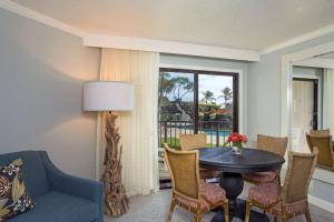 a living room with a table and chairs and a window at Kauai Beach Resort & Spa in Lihue