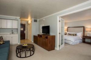 a living room with a bed and a television at Kauai Beach Resort & Spa in Lihue