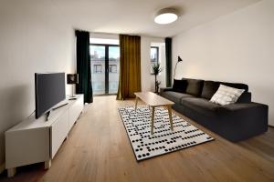 a living room with a couch and a tv at Smart & Green Living by Ambiente in Bratislava