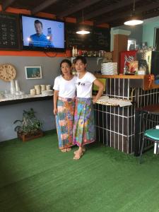 Deux femmes debout à côté d'un comptoir dans un restaurant dans l'établissement Kamala Beach Residence SHA Extra Plus, à Kamala Beach