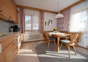 cocina y comedor con mesa y sillas en Apartment Bergsonne, en Samnaun
