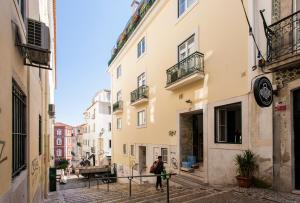 a man walking down a street in an alley at Chiado Patio Apartment in Lisbon