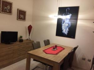 une salle à manger avec une table avec des chaises et une télévision dans l'établissement Casas Blancas Bungalow 45, à L'Alfàs del Pi