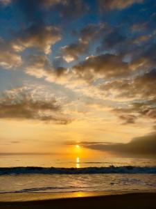 a sunset on the beach with the sun in the sky at St. Tropez in Ocean City