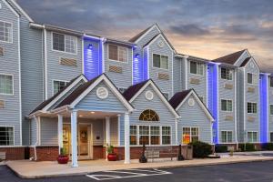 a large apartment building with blue at Microtel Inn & Suites by Wyndham Lillington/Campbell University in Lillington
