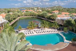 an aerial view of a pool with chairs and palm trees at Acoya Curacao Resort, Villas & Spa in Willemstad