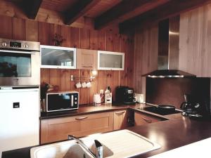 eine Küche mit Holzschränken und einer Arbeitsplatte in der Unterkunft D&O - Guesthouse - "la Pinède" in Saint-Gérons