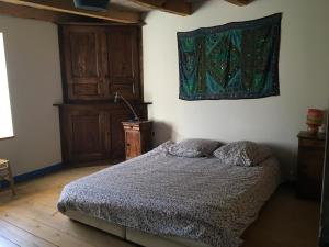 1 dormitorio con 1 cama y una pintura en la pared en Chambres d'hôtes des Deux Lacs, en Ceyzérieu