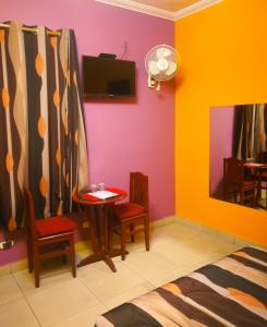 1 dormitorio con paredes coloridas, mesa y sillas en Hostal GQ, en Lima