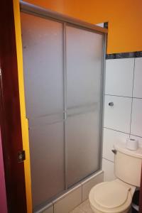 - Baño con aseo y puerta de ducha de cristal en Hostal GQ, en Lima