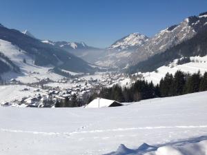 una montaña cubierta de nieve con una ciudad a lo lejos en Ski La Cote, en La Chapelle-dʼAbondance