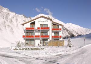 a building in the snow in front of a mountain at Apart Primavera in Samnaun