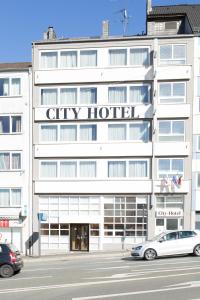 City Hotel Wuppertal في فوبرتال: فندق بالمدينة فيه سيارات تقف امامه