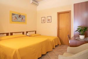 2 łóżka w pokoju hotelowym z żółtą pościelą w obiekcie Al Frantoio Maddii Levane bed and breakfast w mieście Levane
